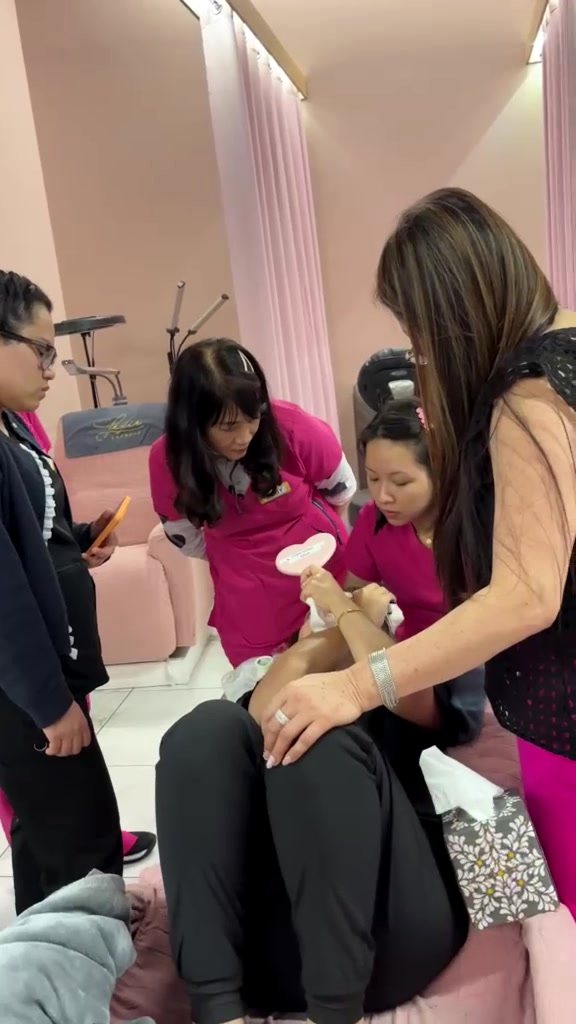 Students gathered around a live model demonstration at Lexie Beauty Academy